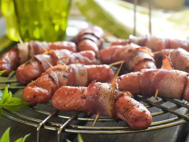 Składniki:
400 g kiełbasek
8 plasterków wędzonego boczku
100 g sera typu mozzarella
2 łyżki posiekanej świeżej bazylii
wykałaczki

Sposób przygotowania: 
Mozzarellę pokrój w plastry, posyp bazylią. Kiełbaski dopraw przyprawą. Na każdej kiełbasce połóż kawałek sera a następnie ciasno owiń plasterkiem boczku. Całość zepnij wykałaczkami tak, aby ser nie wypłynął. Grilluj kiełbaski aż do uzyskania pożądanego wyglądu. 

Więcej przepisów, smaczne miejsca - sprawdź nasz serwis specjalny!