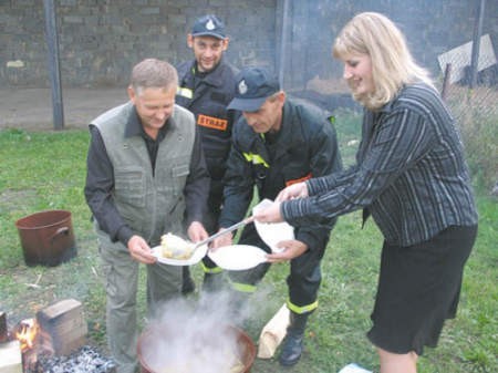 Anna Rawska częstuje pieczonkami Tadeusza Kubika, Arkadiusza Sapotę i Andrzeja Wojdasa.