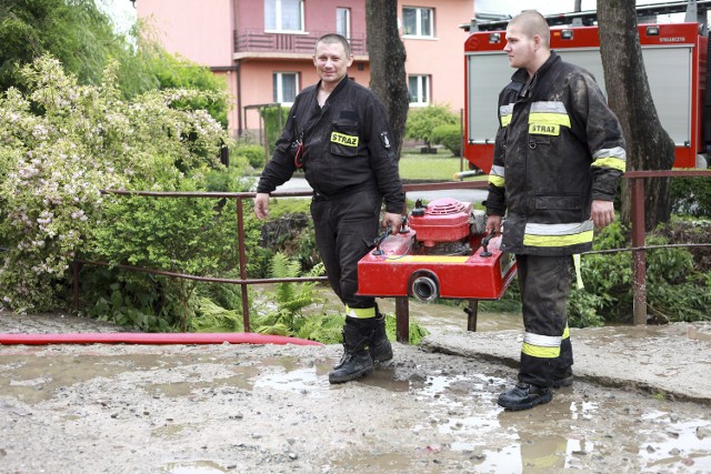 Podobny problem ma około 30 innych mieszkańców wsi, których domy zalała rzeka Białucha. Nawałnica przyszła z poniedziałku na wtorek, około 2 w nocy. - Jeszcze o 1 w nocy jeździłem i sprawdzałem stan rzek, czy wszystko jest w normie. Kiedy wreszcie myślałem, że mogę iść spokojnie spaść, przyszło najgorsze - opowiada Jan Palimąka, komendant Ochotniczej Straży Pożarnej w Zielonkach. W nocy i cały wczorajszy dzień pracował on i wszyscy jego ludzie. (tu: strażacy na posesji Janiny Kurek w Zielonkach)