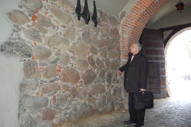 Burmistrz Ryszard Sylka wskazuje, gdzie zostanie umocowana tablica pamiątkowa