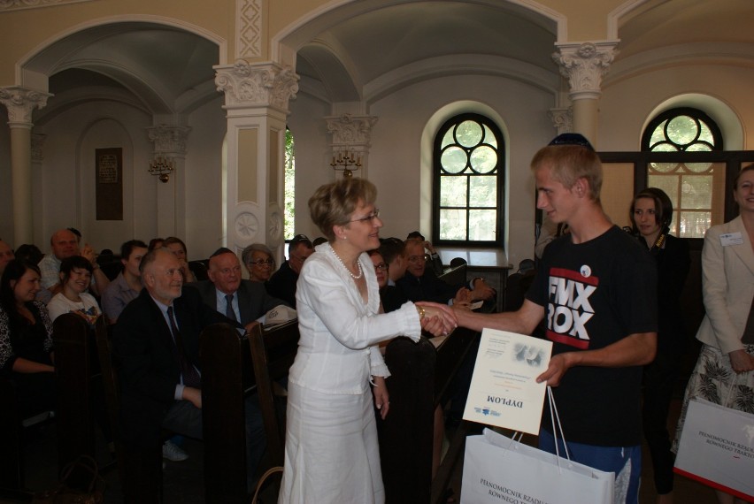 Adrian Nowak otrzymuje dyplom i gratulacje z rąk Pani...
