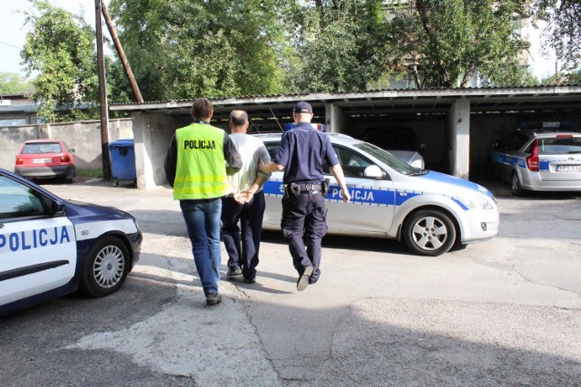 Policjanci z KPP Wadowice prowadzą zatrzymanego oszusta do Prokuratury Rejonowej w Wadowicach.