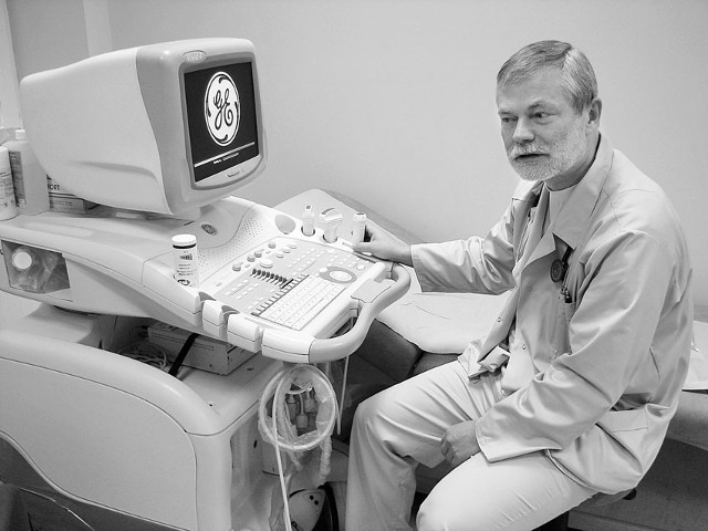 Dyrektor Zbigniew Jarosik przy ultrasonografie, który zapisuje wynik badania na płycie CD.
