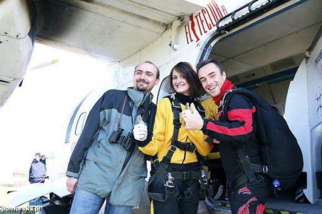 Katarzyna Kwiatkowska z chłopakiem Józef Kowalski (z lewej) oraz instuktorem Maciejem Węgrzewskim na tle samolotu, z pokładu którego odbył się skok