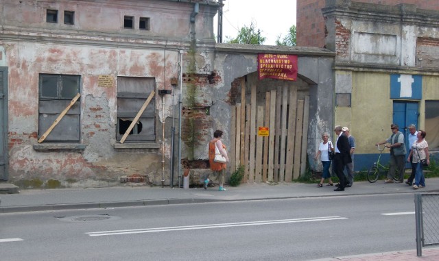 Właściciel zabił deskami okna i drzwi budynku, a w głównej bramie ustawił ścianę z desek.