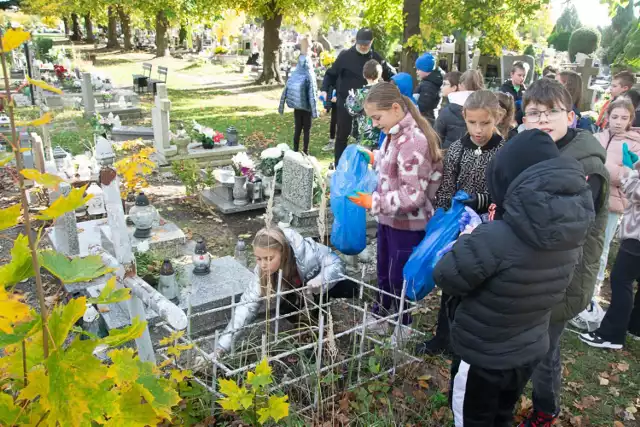 Sprzątanie grobów na żarskim cmentarzu. Uczniowe SP  2 im. Janusza Korczaka w Żarach przyszli na cmentarza w ramach lekcji wychowawczej