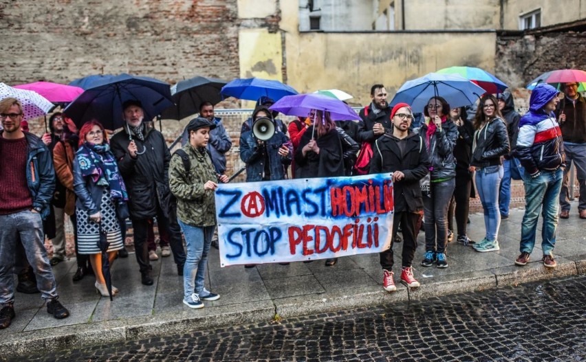 Protestujący stali w strugach deszczu, trzymali transparent...