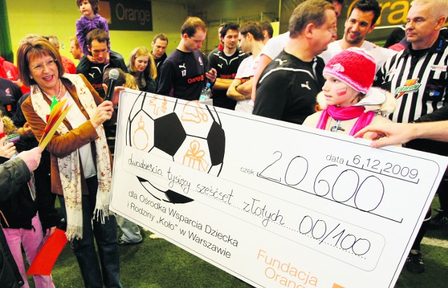 Jadwiga Czartoryska, prezes Fundacji Orange, wręcza dzieciom czek na 20 600 złotych