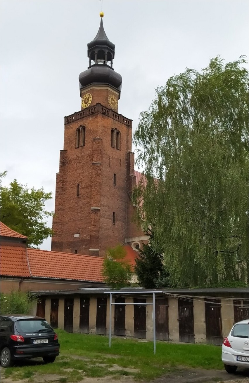 Widok na kościelną wieżę z podwórza przy ulicy Chrobrego