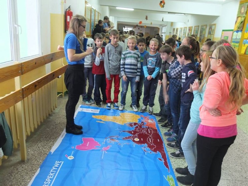 Mapa świata z zmienioną perspektywą - Australia w centrum. Wolontariuszka Sylwia Szulc wraz z uczniami podczas omawiania nowej dla uczniów mapy.