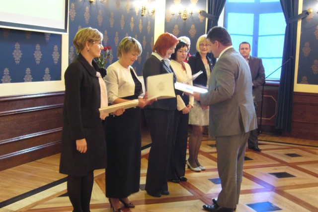 Wiceprezydent Leszek Szulc wręcza nauczycielom nagrody finansowe.