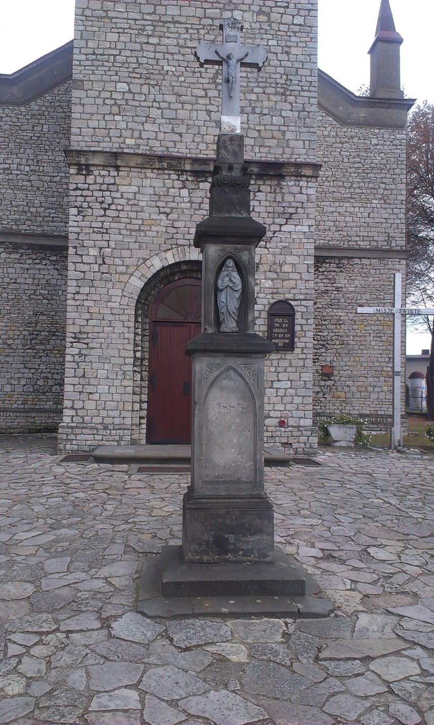 Kamienny krzyż na postumencie przed kościołem w Żyglonie...