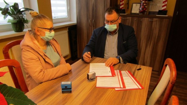 Moment zawierania umowy przez wójta Marka Szczypiora z Wiolettą Szaruga reprezentującą Firmę Handlowo-Usługową "SZARUGA"