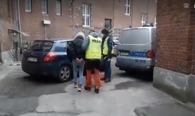 Moment przewozu zatrzymanej kobiety z policji do prokuratury (na drugą stronę ulicy)