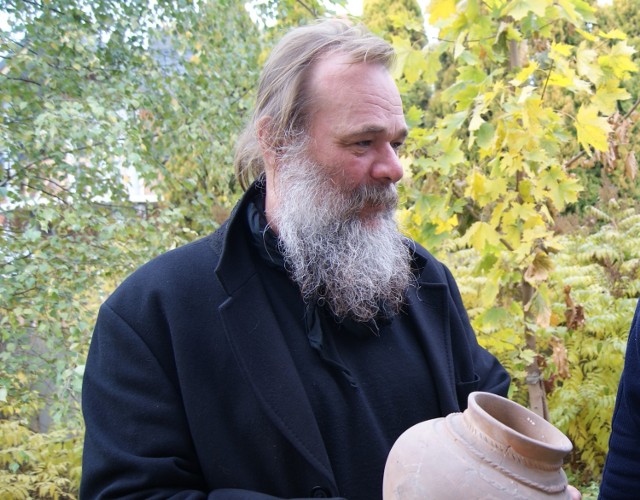 Archeolog Leszek Ziąbka prezentuje gliniane naczynie celtyckie