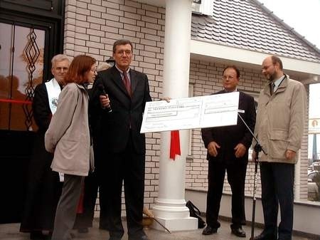 Z okazji otwarcia domu wzorcowego Udo Zimmermann z firmy KAMPA przekazał gminie Tarnowo Podgórne czek  na 10 tys. zł.