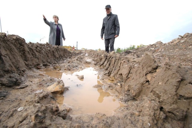 Irena Juszczak i Eugeniusz Paluch przedzierają się przez błotny wąwóz. Mieszkańcy ulicy Andersa chcieliby, żeby drogowcy zrobili prowizoryczny chodnik prowadzący do ulicy Wojska Polskiego, ale drogowcy podkreślają, że tu znajduje się teren budowy i chodzić tędy nie wolno.