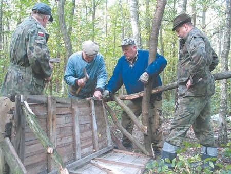 Członkowie koła łowieckiego naprawiają paśniki.