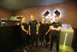 Śląski Klub Fitness Smart Gym w CH Załęże w Katowicach po remoncie jest jak kopalnia. Czarne wnętrza i Korfanty. Projekt: DD Architekci