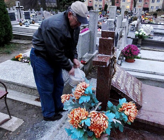 Tadeusz Recki sprząta grób bliskich na cmentarzu w Sławnie