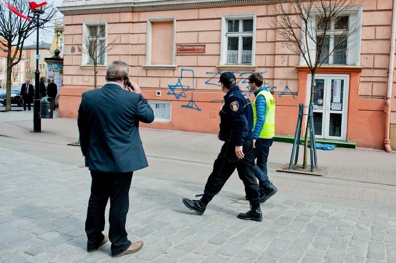 Wojciech Krawczyk i straż miejska przyglądają się napisowi