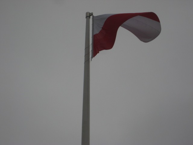 Polska flaga radośnie powiewająca na Rondzie Radosława w Warszawie