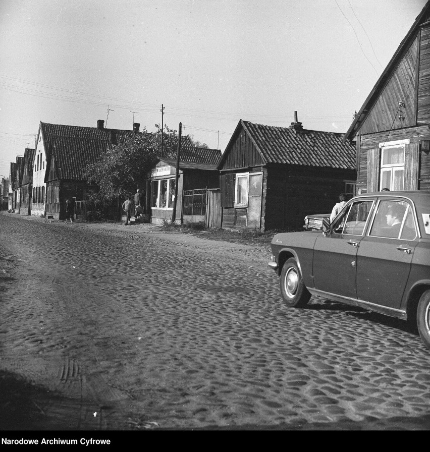 Stare domy przy brukowanej ulicy Młynowej. Z prawej samochód...
