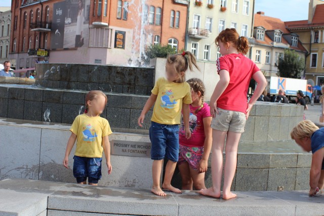 Dzieci bawiące się (mimo zakazu) na boso w fontannie na gnieźnieńskim rynku. Bardzo dobrze widać na zdjęciu, że nikt - ani dorośli, ani dzieci nie przejmują się tak dobrze widocznym zakazem.