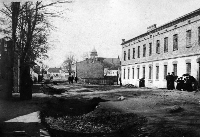 Ulica Kościuszki w 1914 roku, czyli główna bełchatowska arteria - bita droga pełna wybojów, biednie odziani ludzie i liche płoty. Taki Bełchatów opisywał Anszperger