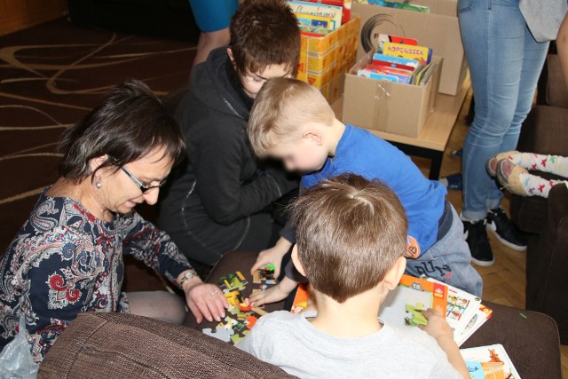 Bibliotekarka Beata Tracz bawi się z dziećmi podarowanymi książeczkami