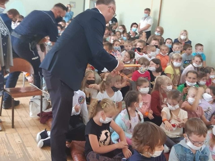 Wiceminister Piotr Wawrzyk rozdawał dzieciom opaski...