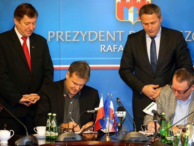 Paull Bellamy i Andrzej Polkowski podpisują umowę, a przyglądają się ceremonii prezydenci Rafał Bruski (z prawej) i Jan Szopiński.