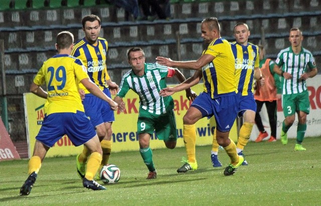 Piłkarze Arki (żółto-niebieskie stroje) momentami osaczali zawodników Olimpii, jak w tym przypadku Marcina Kaczmarka.