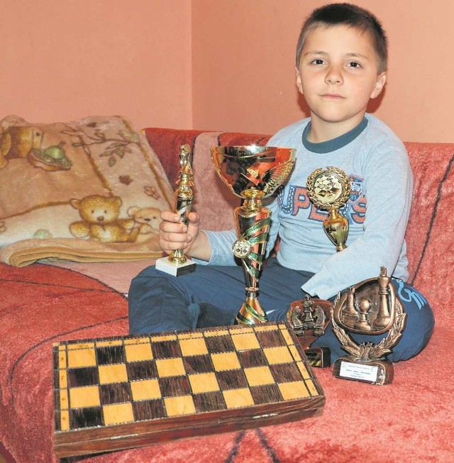Bartek z trofeami, które wygrał w szachy sam lub z tatą.