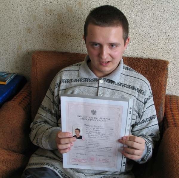 Mariusz z dumą pokazuje dyplom ukończenia studium o kierunku technik bezpieczeństwa i higieny pracy.