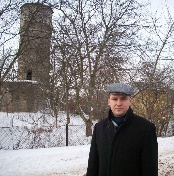 Przewodniczący rady Osiedla Kolonia Robotnicza Grzegorz Stawiarski obok opuszczonej wieży i pawilonu.