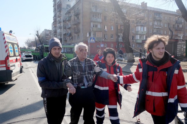 Ratownicy prowadzą rannego po rosyjskich atakach w Kijowie