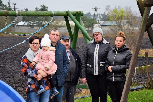 Pod petycją sprzeciwiającą się rozbudowie fermy zebrali około 200 podpisów. Na zdjęciu delegacja protestujących. Za nimi już istniejące kurniki.