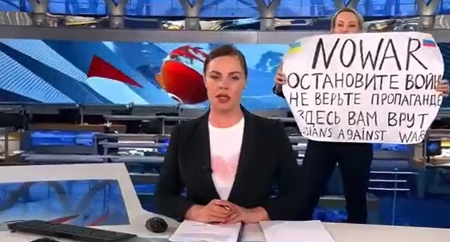 Marina Owsiannikowa pokazała arkusz z napisem NO WAR (nie dla wojny) po angielsku. Było tam również napisane wezwanie by „nie wierzyć propagandzie” i stwierdzenie „tu was okłamują”