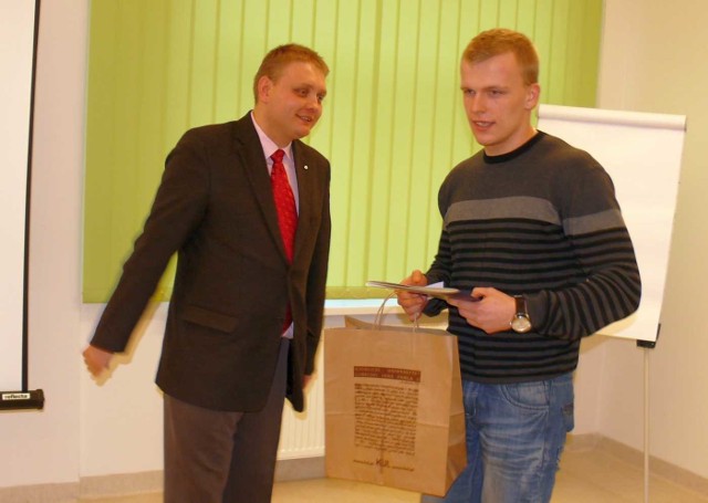 Zdobywca pierwszego miejsca Bartłomiej Kowalczykl odbiera nagrodę z rąk dra Marcina Pycia.