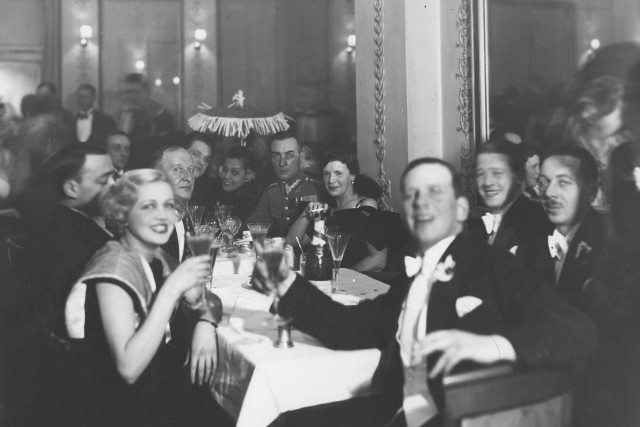 Grupa uczestników balu przy stoliku. Widoczny m.in. aktor Eugeniusz Bodo (siedzi przy stole 4. z lewej)
