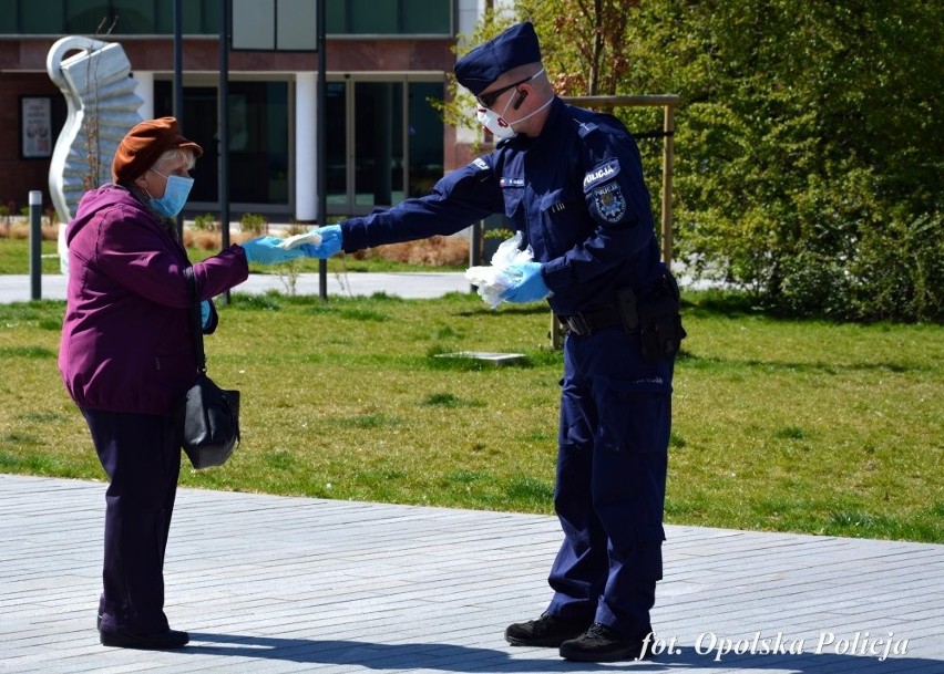 Opolscy policjanci rozdają maseczki na ulicach miasta.