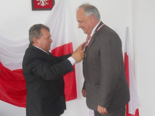 Obecny wójt Ryszard Borowski (z lewej) wręcza pamiątkowy medal pierwszemu wójtowi Markowi Kulikowi.