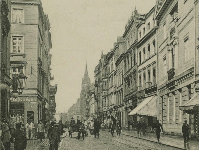 Cztery lata później mieszkał już jednak przy Szerokiej 18, w kamienicy z masztem widocznej po prawej stronie. To stąd na początku sierpnia 1902 roku wyprowadzili go żandarmi