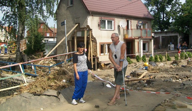 Na zdjęciu Anna Borowiak i Waldemar Janiszewski na tle zrujnowanych domów i ulic Bogatyni