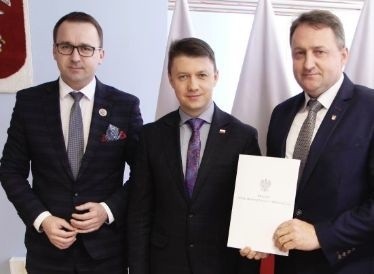 Dariusz Skiba - z prawej, burmistrz Bodzentyna po odbiorze promesy. Obok niego wicewojewoda Bartłomiej Dorywalski i poseł Michał Cieślak.
