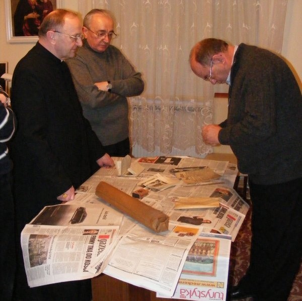 Zawartość kuli z katedralnej wieży badają (od lewej) ks. bp Paweł Stobrawa, ks. infułat Edmund Podzielny, proboszcz katedry opolskiej, oraz Jan Kornek, dyrektor Archiwum Państwowego w Opolu.