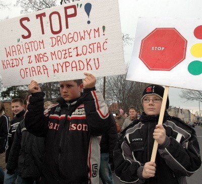 Uczniowie nieśli w rękach transparenty z napisem ,,Stop piratom drogowym&#8217;&#8217;.