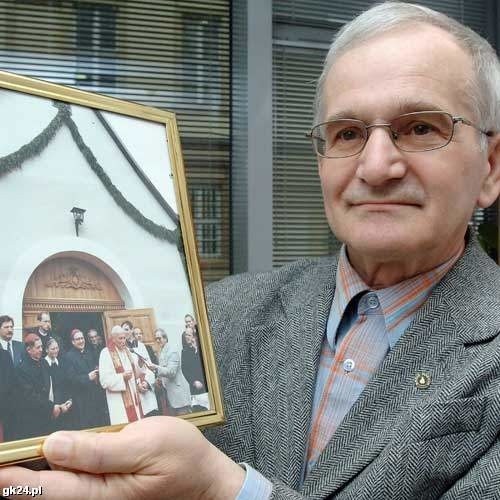 Zbigniew Mikulski pokazuje zdjęcie, na którym widać jak trzyma mikrofon, przez który przemawia Ojciec Święty.