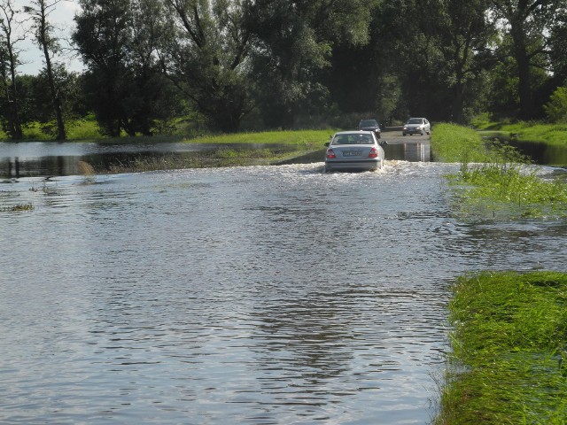 Kierowcy próbują pokonywać zalaną trasę.